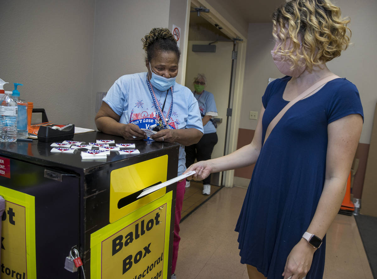Elections worker Robin Wright, left, looks on as Aliy Bossert drops off her mail-in ballot duri ...