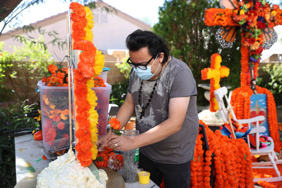 Isaias Urrabazo works on his Dia de los Muertos altar at his home in Las Vegas, Saturday, Oct. ...