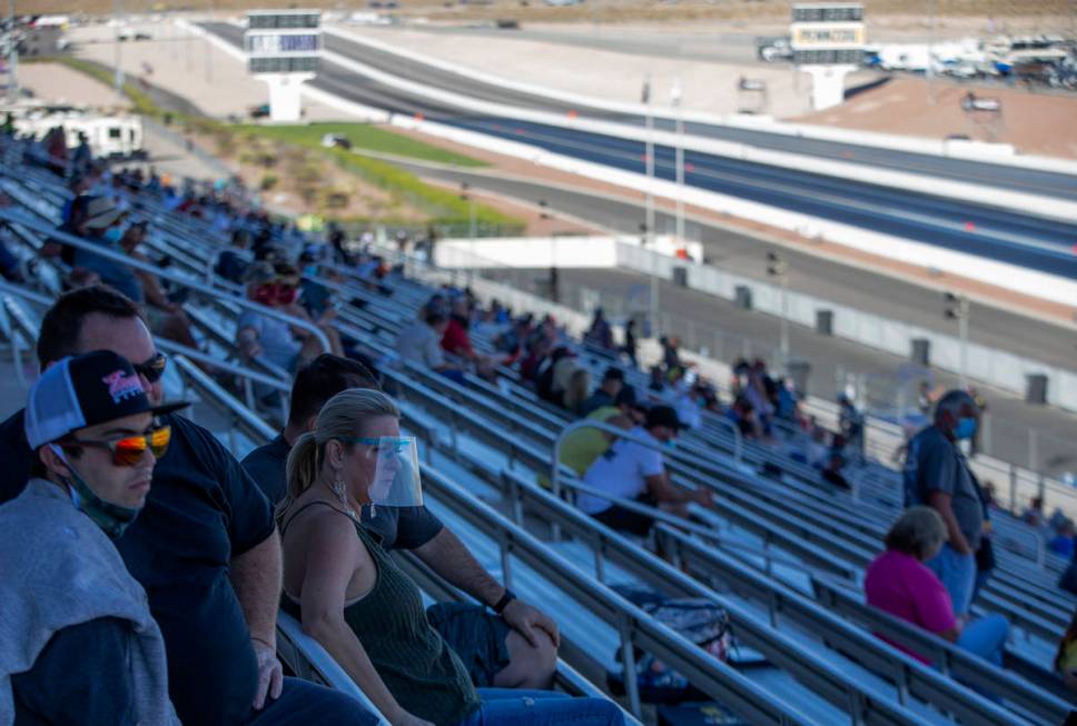Some fans wear personal protective equipment while watching the Dodge NHRA Finals at Las Vegas ...