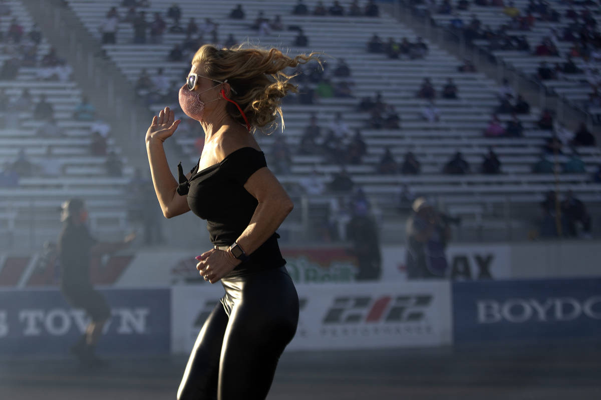 A member of Funny Car driver Alex Miladinovich's crew runs on the track during the Dodge NHRA F ...