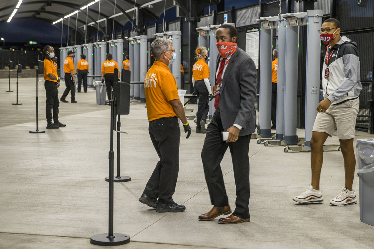 Fans William Wheeler, center, and Lawrence Murray, right, pass by security as they enter Allegi ...