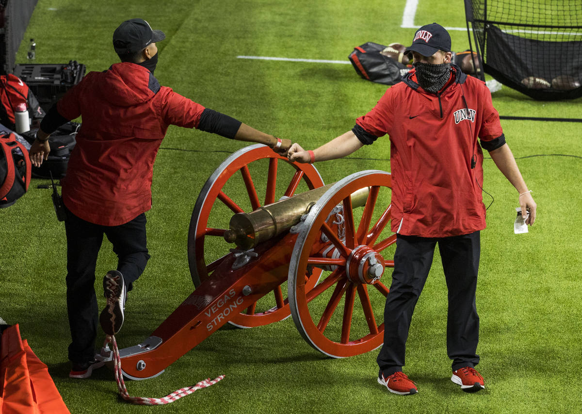 UNLV staffers fist bump after wheeling out the Fremont Cannon during the first half of their NC ...