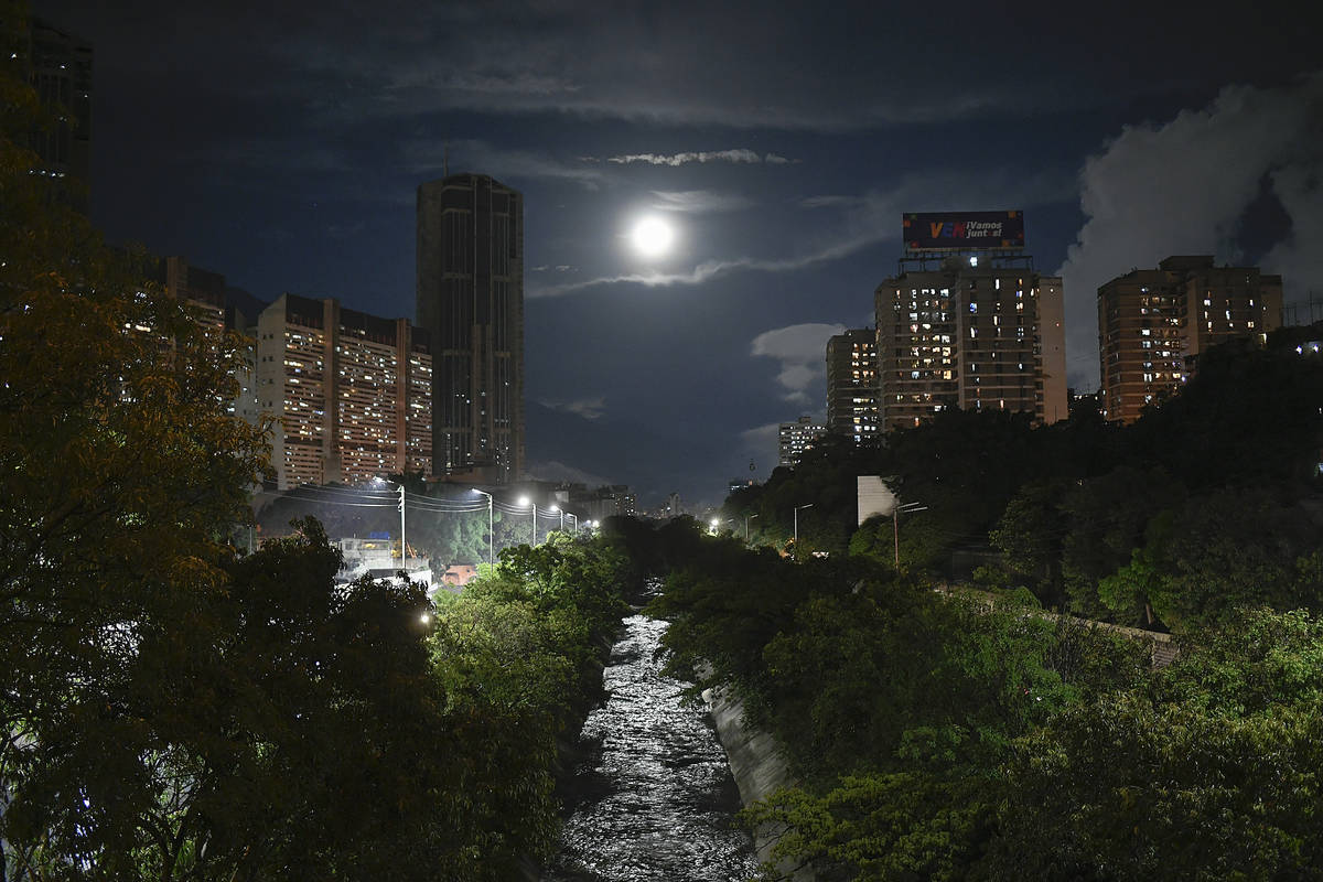 The El Guaire River is illuminated by a full moon in Caracas, Venezuela, Saturday, Oct. 31, 202 ...