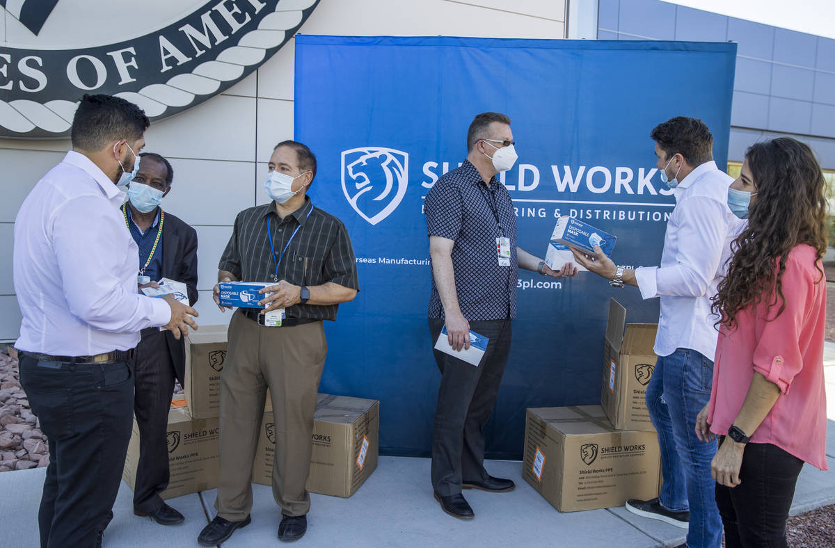 The owners of Shield Works gather with VA Hospital personnel to donate 100,000 masks to the fac ...