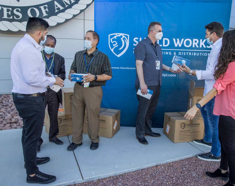 The owners of Shield Works gather with VA Hospital personnel to donate 100,000 masks to the fac ...
