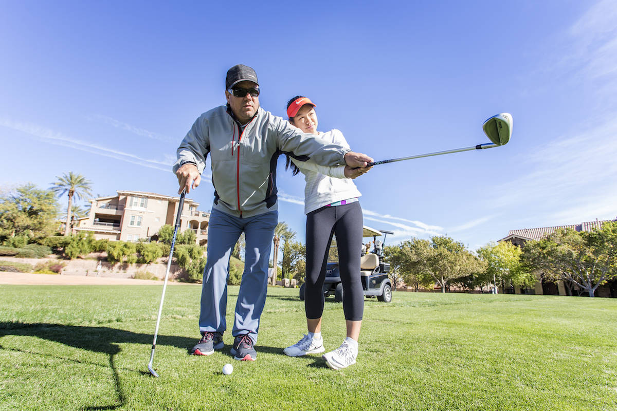Tour Pro Craig Barlow shows student Natalie Cheong how to properly swing a golf club at the Hig ...