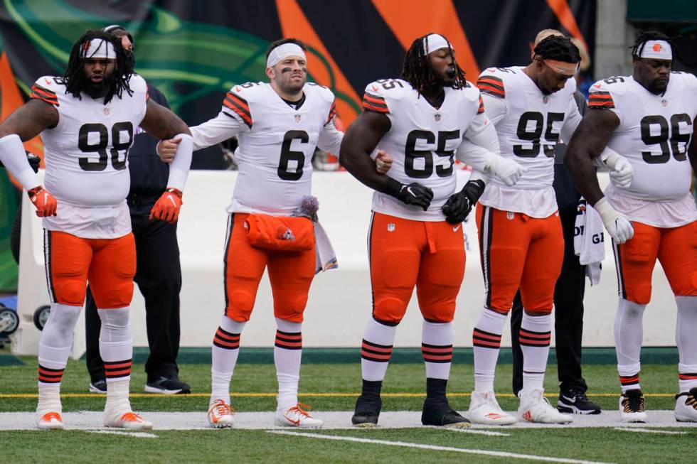 Cleveland Browns quarterback Baker Mayfield (6) locks arms with teammates during the national a ...