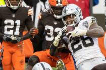 Las Vegas Raiders running back Josh Jacobs (28) fights for extra yardage with Cleveland Browns ...