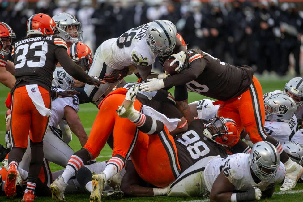 Las Vegas Raiders running back Josh Jacobs (28) leaps over against the Cleveland Browns defende ...