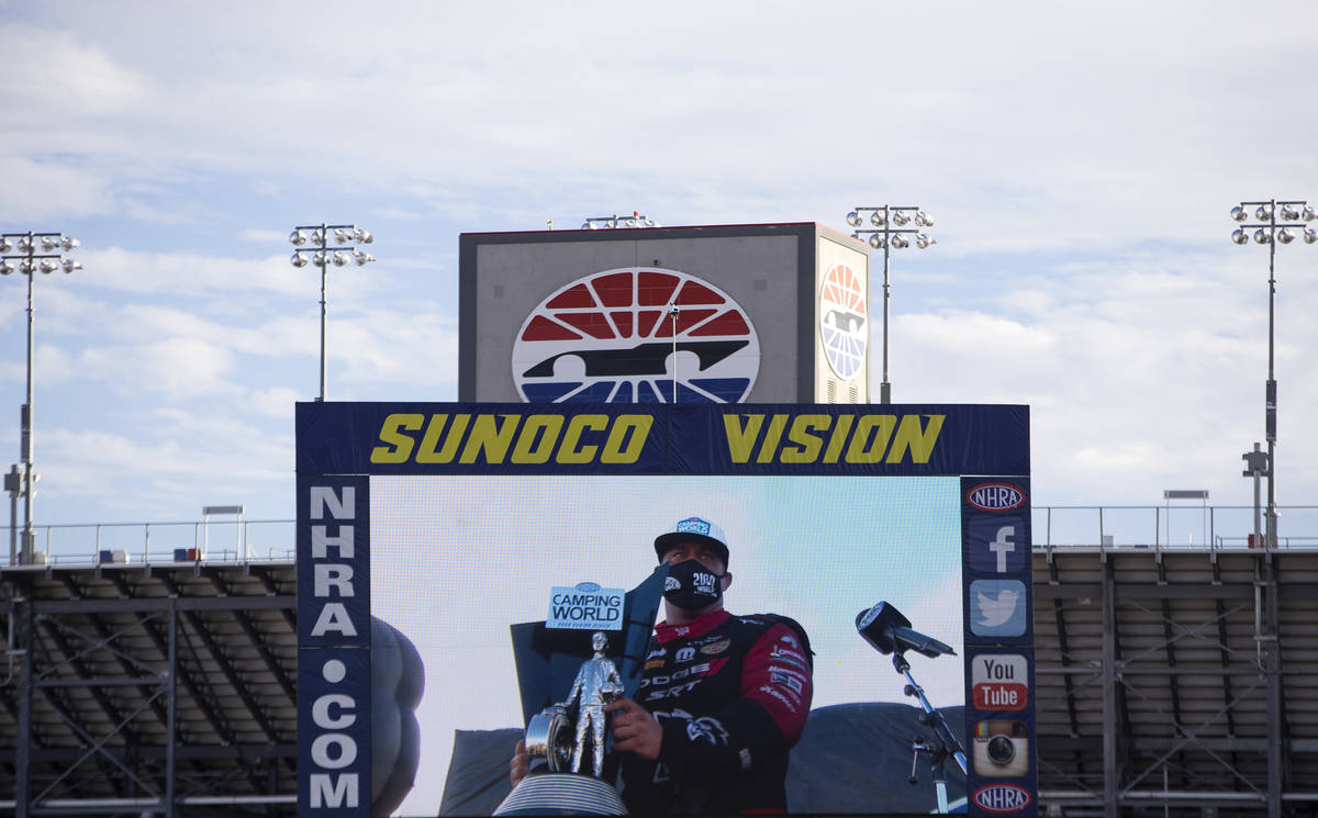 Funny Car driver Matt Hagan accepts his trophy on screen during the Dodge NHRA Finals at Las Ve ...