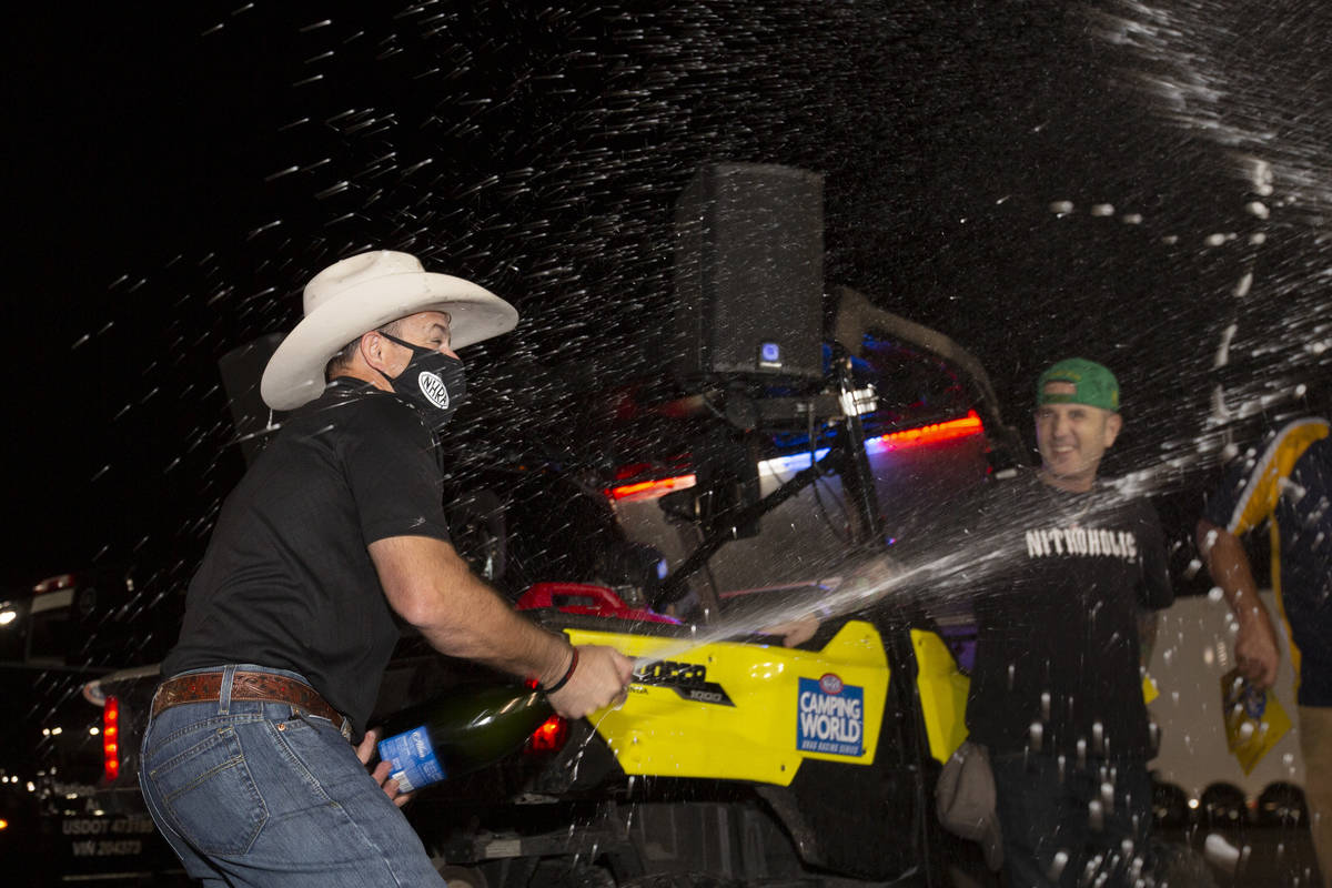 Top Fuel driver Steve Torrence sprays champagne in celebration of winning the NHRA Camping Worl ...
