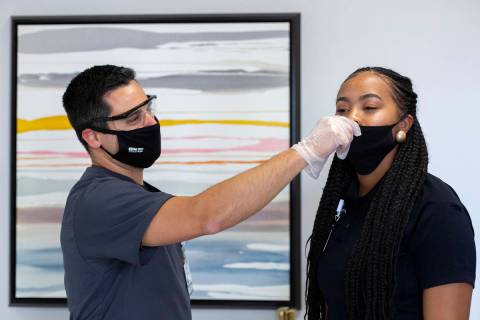 Honey Stayton, communication specialist at Elite Medical Center, undergoes a nasal swab to test ...