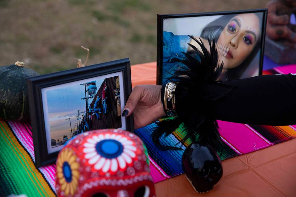 Ingrid ollintzihuatl Moctezuma sets out photos on an ofrenda at a Día de los Muertos event ...