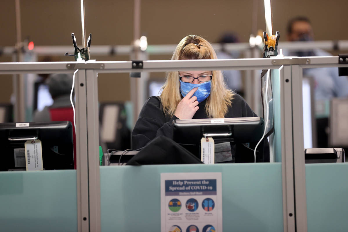 Jennifer McKay of Las Vegas votes at 7:35 a.m. surrounded by empty voting machines at Desert Br ...