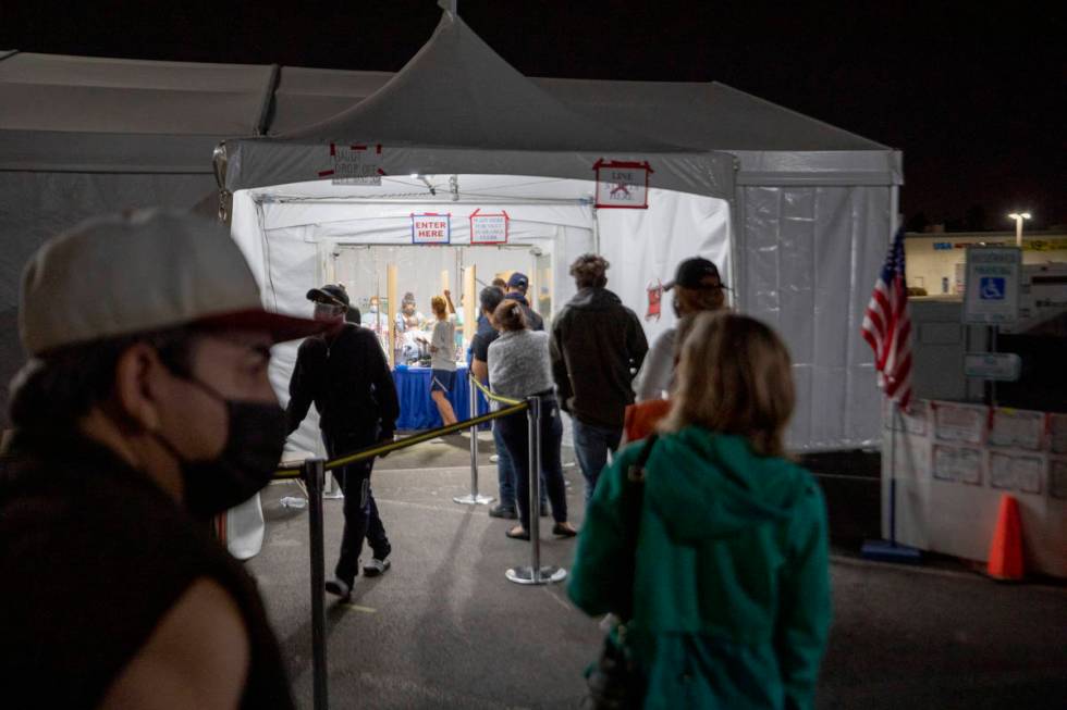 Individuals wait in line to cast their ballot at the Boulevard Mall polling station before it c ...