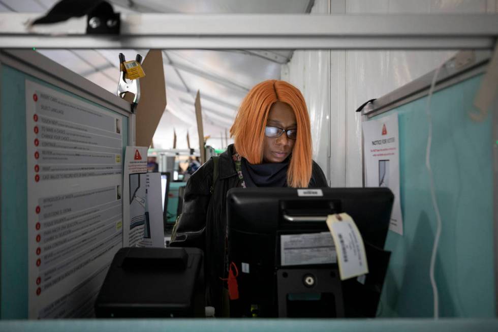 Hollany McKinnis, 41, of Henderson, casts her ballot at the Boulevard Mall polling station minu ...