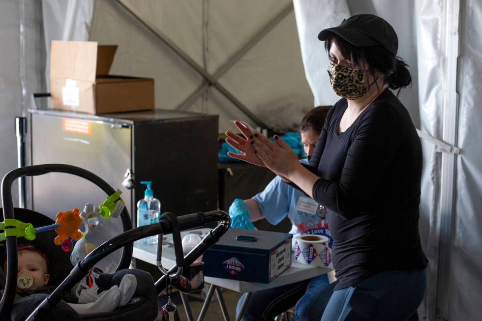 Kristiana Schiro, who brought her 6-month-old daughter Kara Kuebler along, puts on hand sanitiz ...