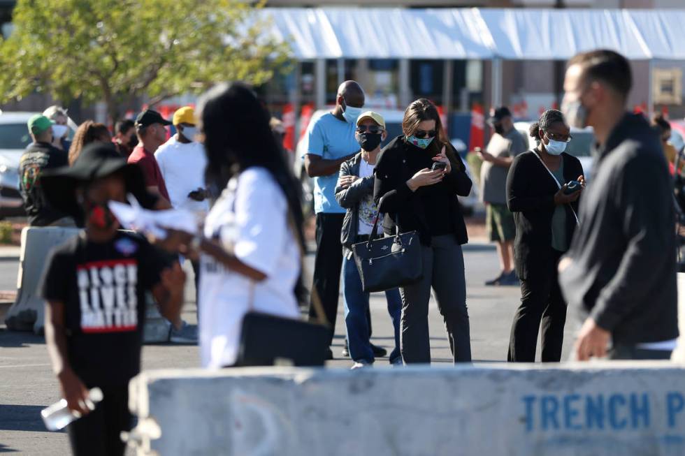 People wait in line to cast their vote at the Galleria at Sunset polling station in Henderson, ...