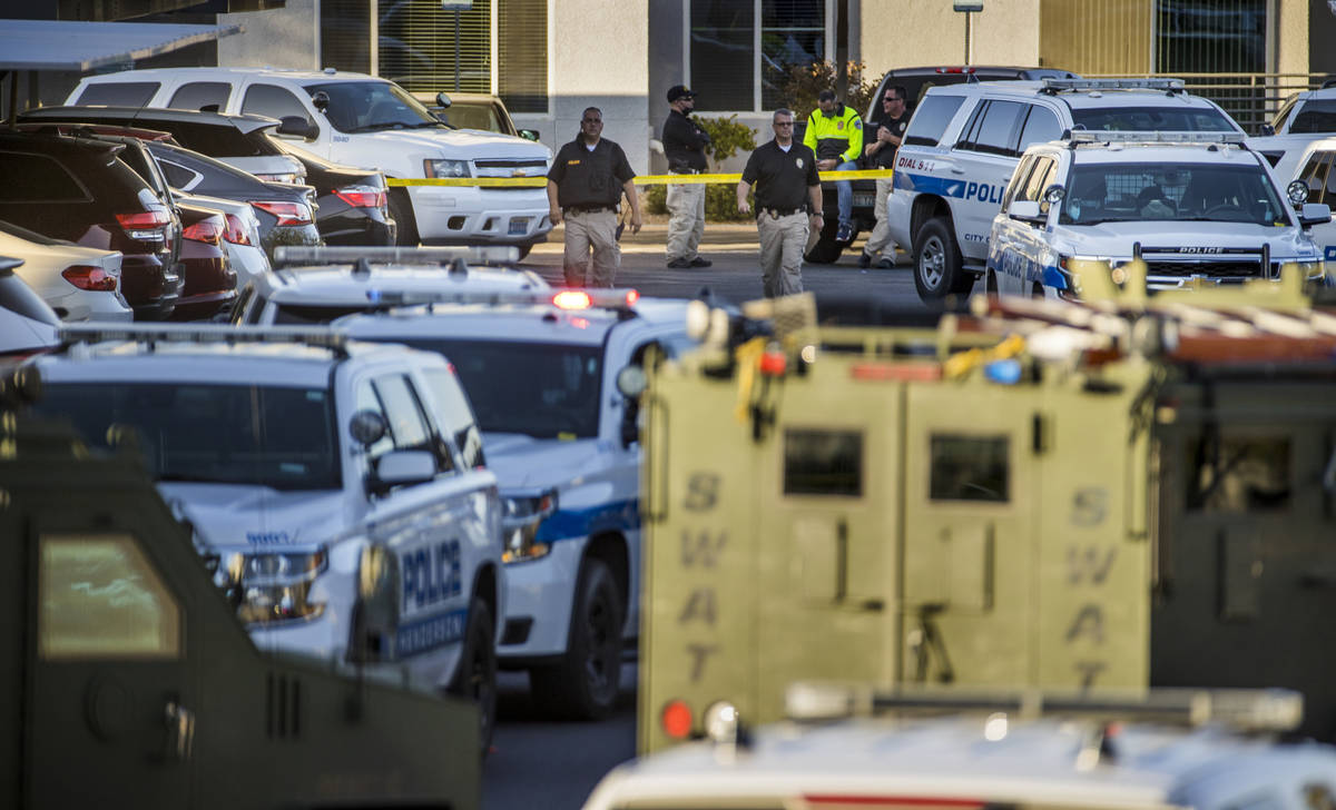 Officers move about outside after four were killed and one injured in police shooting at The Do ...