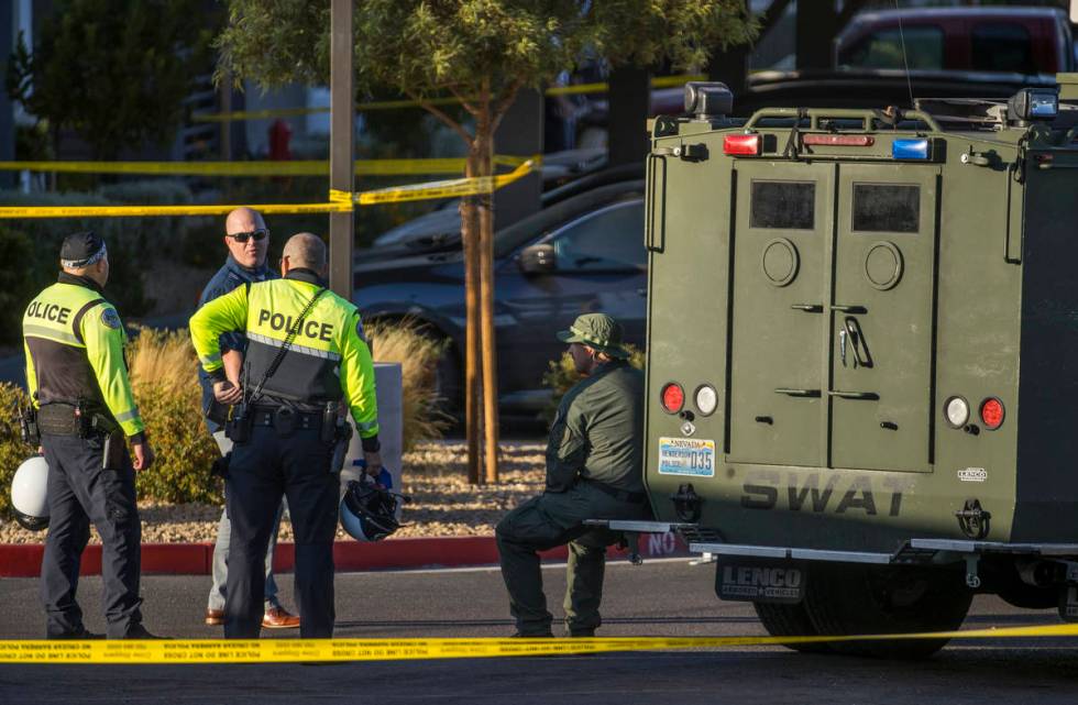 Emergency personnel as well as a SWAT vehicle about the parking lot after four were killed and ...