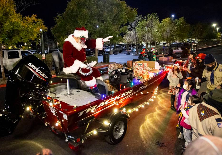 Santa Claus greets people and hands out toys during a parade at Bass Pro Shops in Las Vegas on ...
