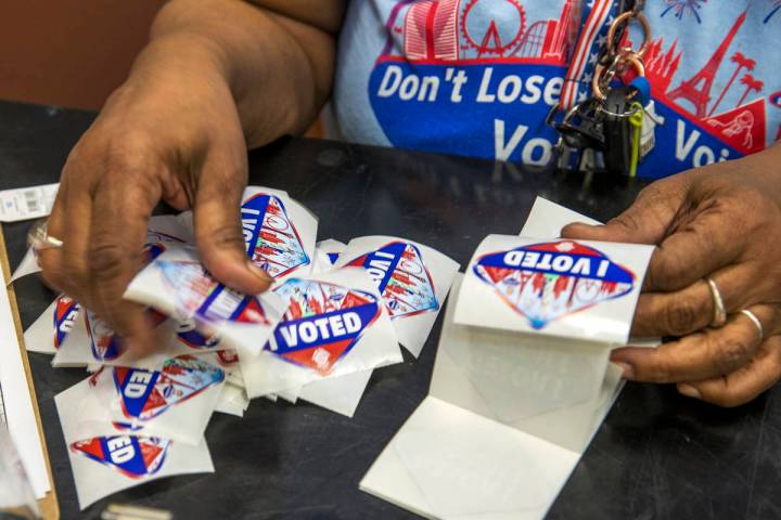 Elections worker Robin Wright readies ÒI VotedÓ stickers for mail-in ballot drop off ...