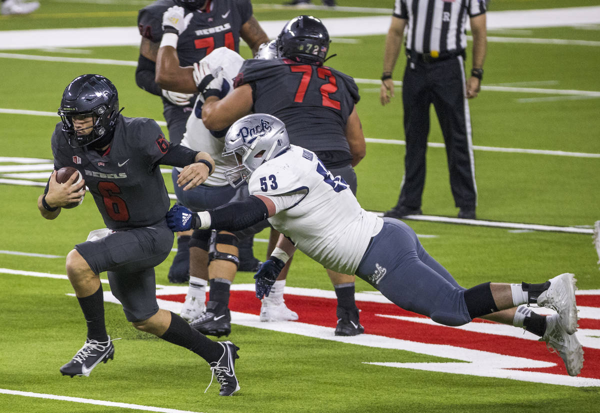 UNLV Rebels quarterback Max Gilliam (6, left) sprints down the field past a diving Nevada Wolf ...