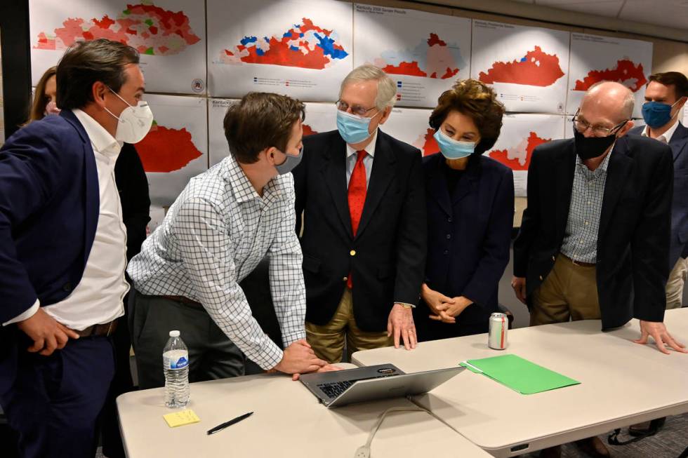 Republican Senate candidate Sen. Mitch McConnell, center, talks with a staff member as they gat ...