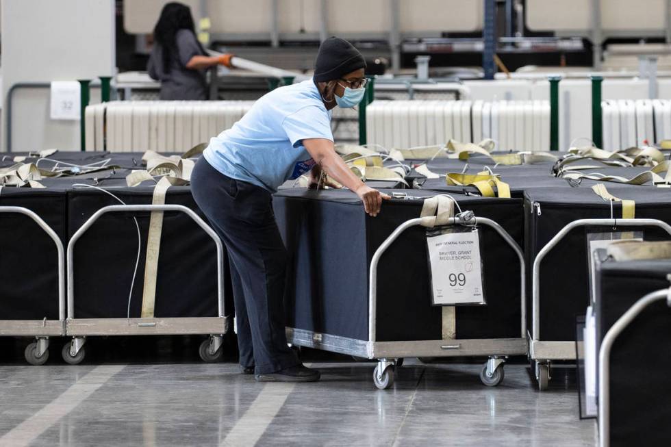 A Clark County election worker arranges voting machines at the Election Center on Wednesday, No ...