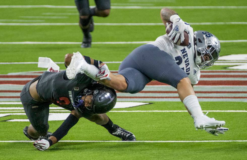 UNR Wolf Pack running back Toa Taua (35) is taken down by UNLV Rebels defensive back Dominic Br ...
