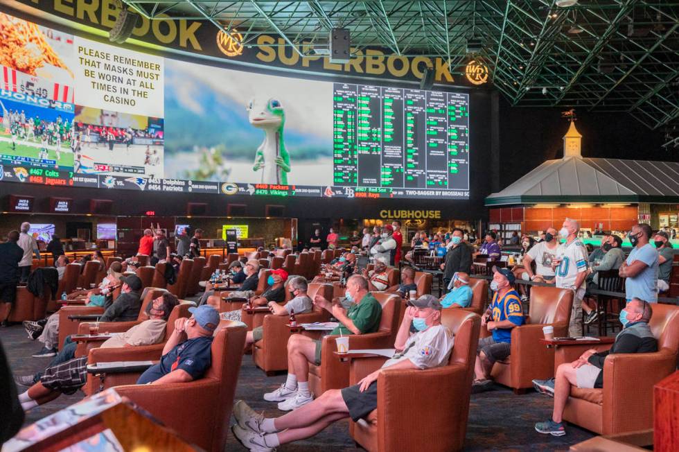 Individuals watch games at the Westgate Sportsbook during opening weekend, in Las Vegas on Sund ...