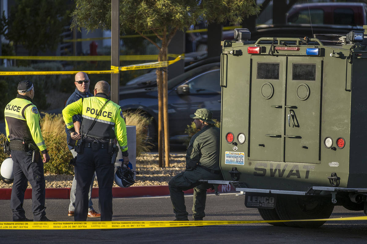Emergency personnel as well as a SWAT vehicle about the parking lot after four were killed and ...