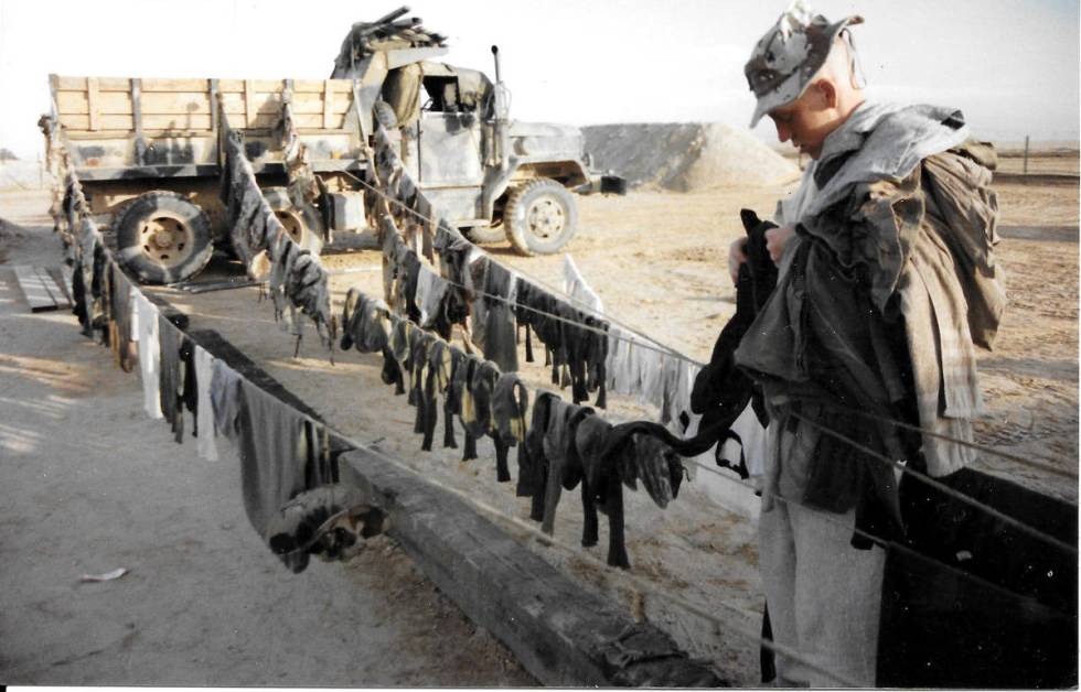 Pfc. Rocky McKenzie collects laundry after a long day of chores near King Khalid Military City ...