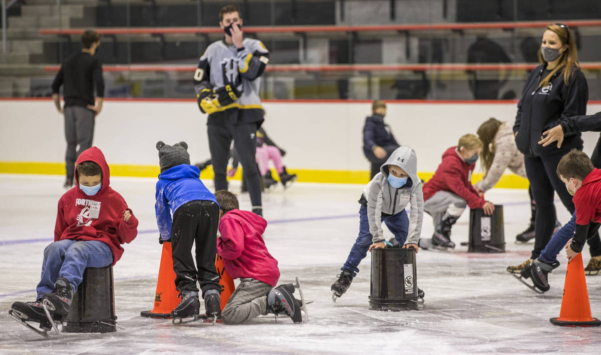 Youngsters with the Battle Born Kids Program use cones and buckets to stay upright on the ice d ...