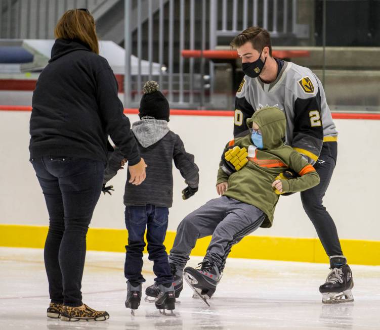 New Vegas Golden Knights goaltender Logan Thompson, right, helps a youngster with the Battle Bo ...