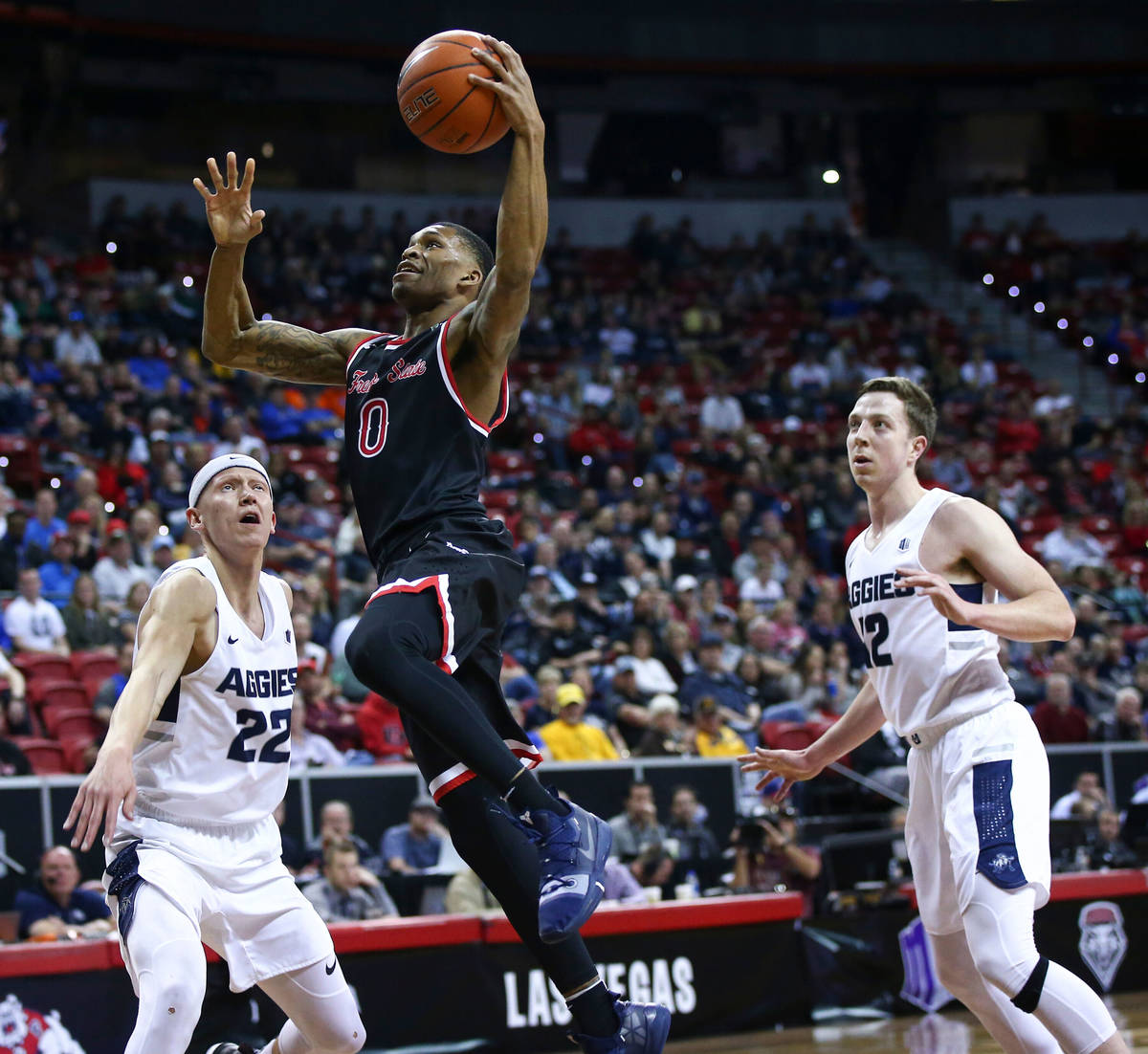 Fresno State Bulldogs guard New Williams (0) goes to the basket between Utah State Aggies guard ...