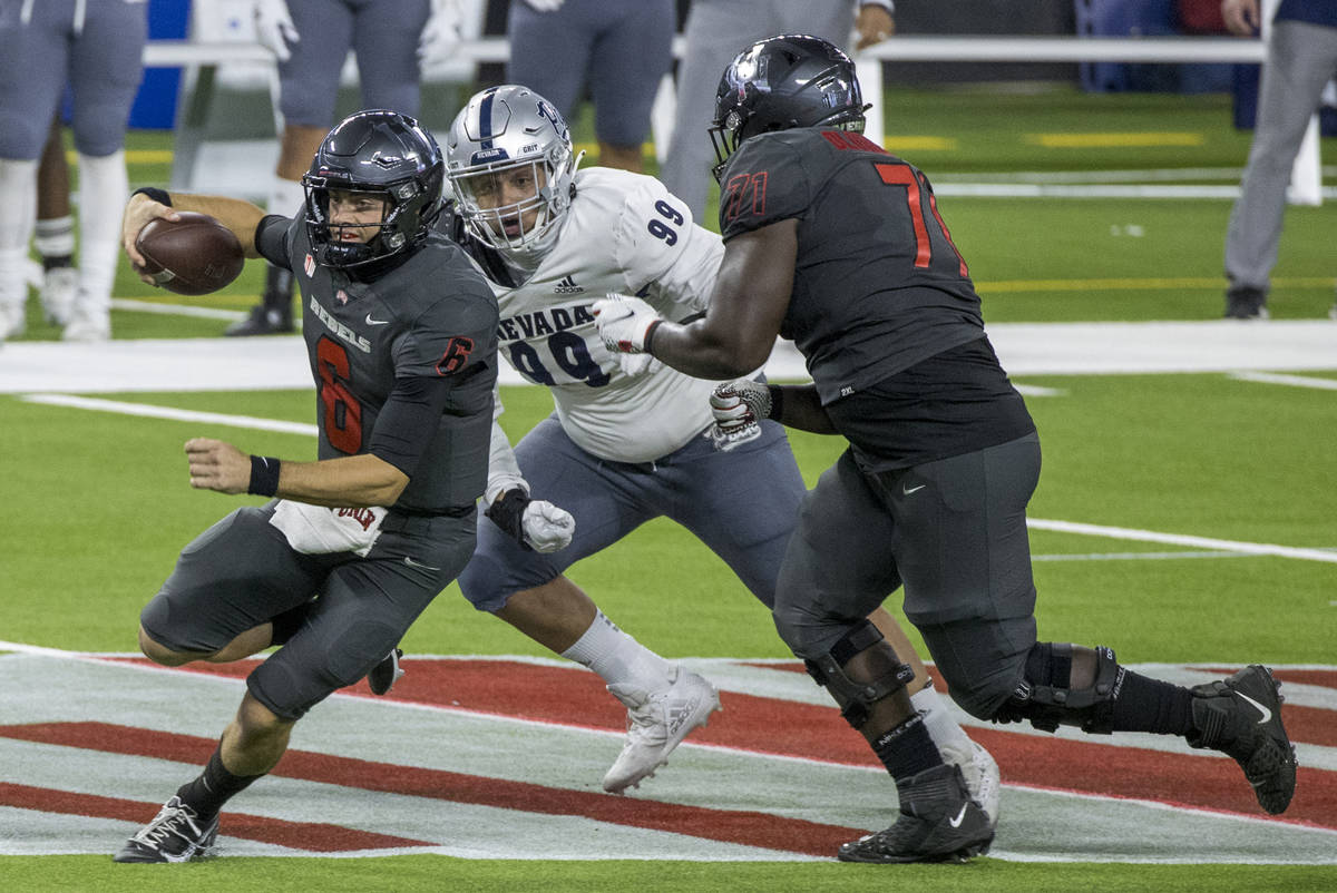 UNLV Rebels quarterback Max Gilliam (6) looks for daylight as he runs past the Nevada Wolf Pack ...