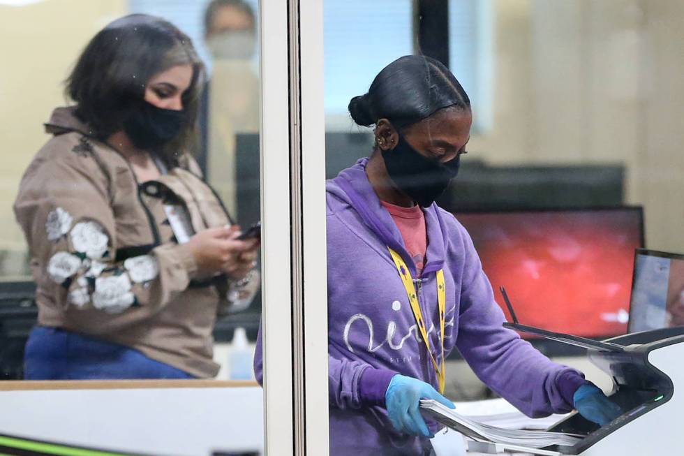 A county election worker scans mail-in ballots at a tabulating area at the Clark County Electio ...