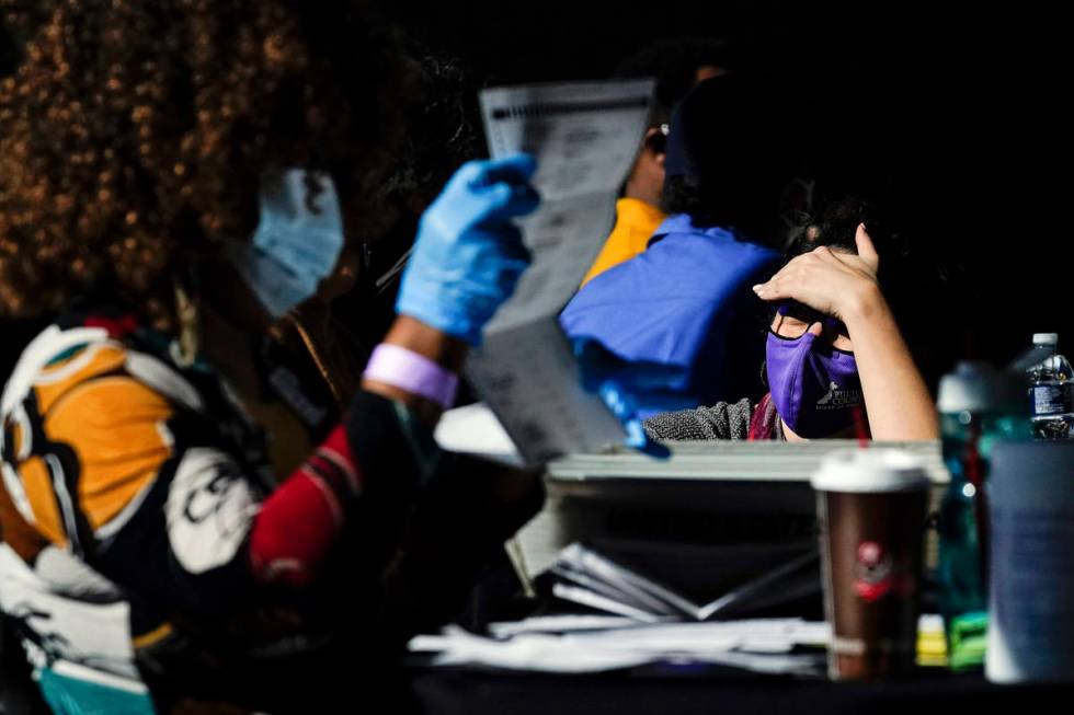 An election supervisor answer questions from an election worker as vote counting in the general ...