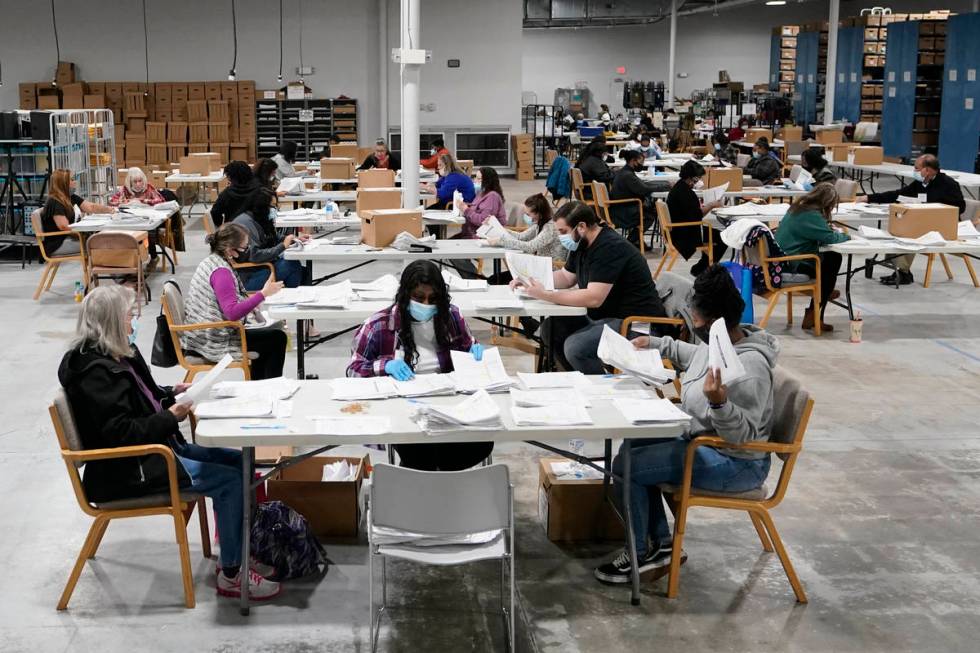 Officials work on ballots at the Gwinnett County Voter Registration and Elections Headquarters, ...