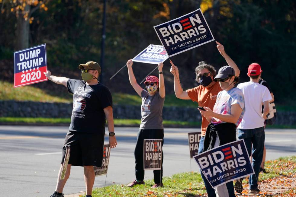 Supporters of President-elect Joe Biden wave signs at the entrance to Trump National golf club ...