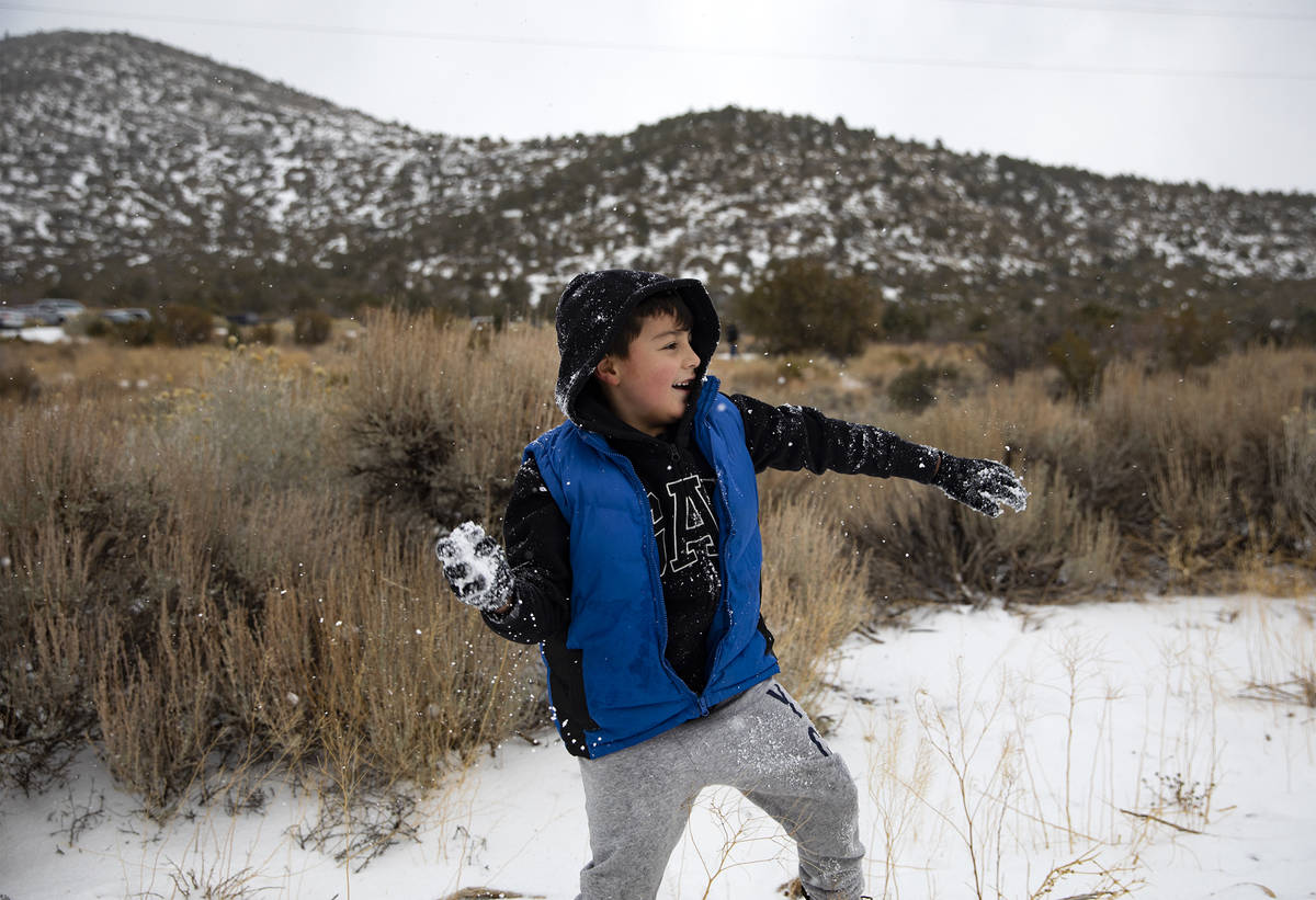 Aaron Vasquez, 8, throws a snowball while playing with his brothers at Mt. Charleston, Sunday, ...