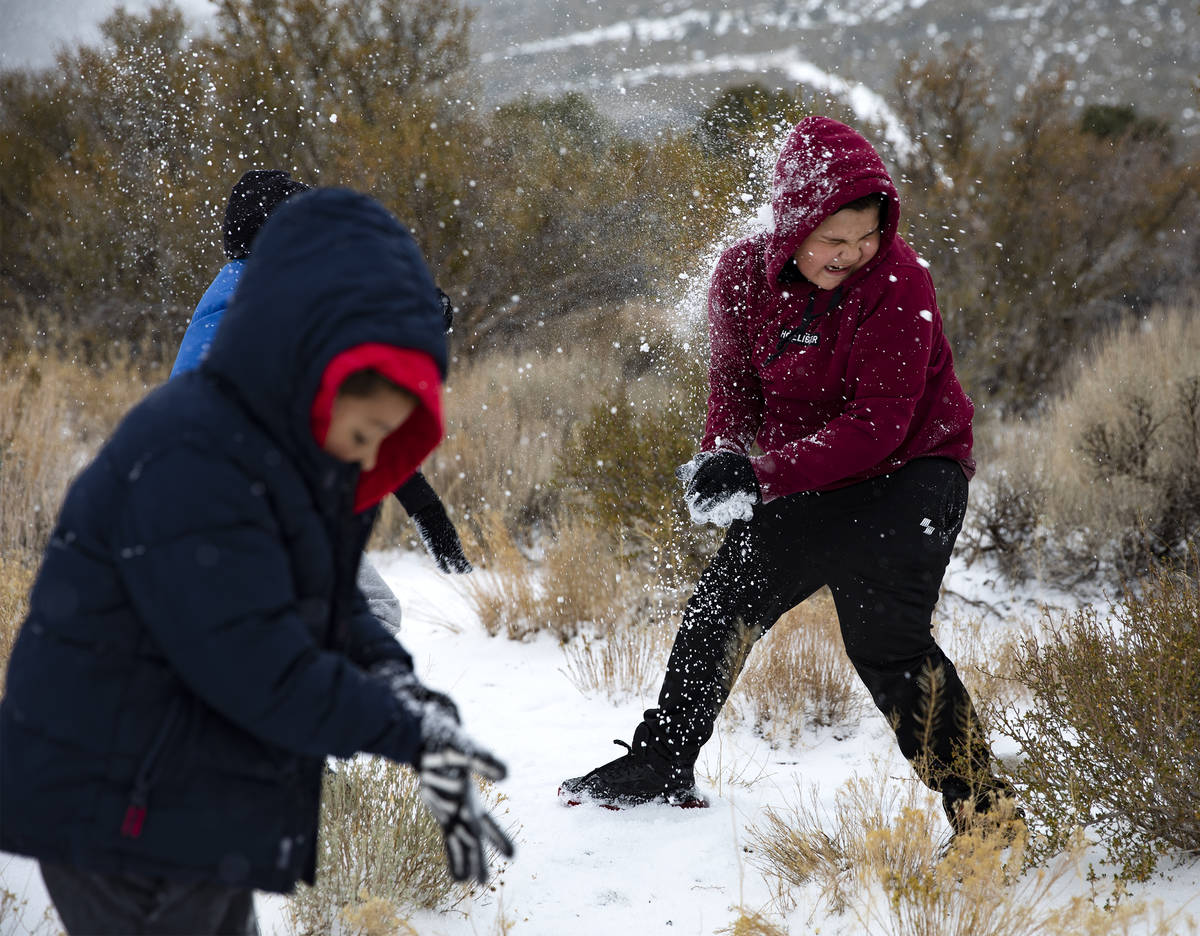 Aaron Vasquez, 8, throws a snowball at his brother Max Vasquez, 10, as they play at Mt. Charles ...