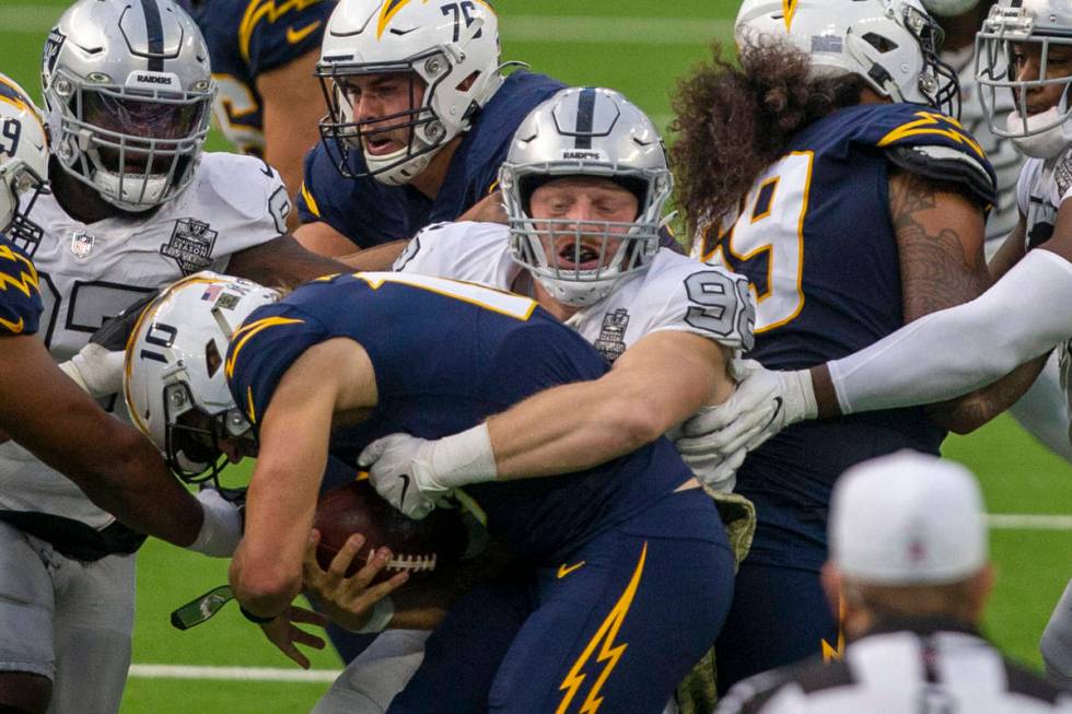 Las Vegas Raiders defensive end Maxx Crosby (98) sacks Los Angeles Chargers quarterback Justin ...