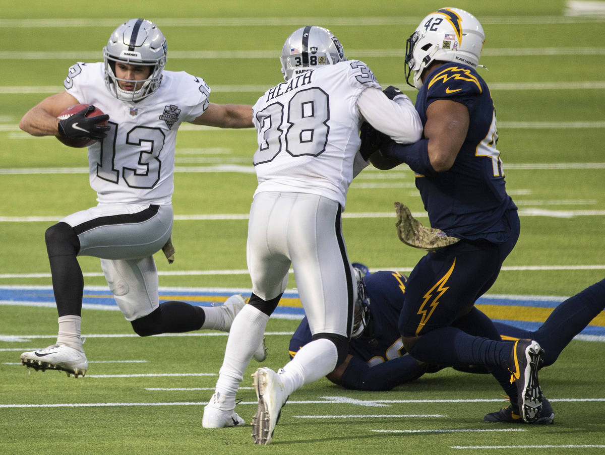 Las Vegas Raiders wide receiver Hunter Renfrow (13) turns the corner around Los Angeles Charger ...