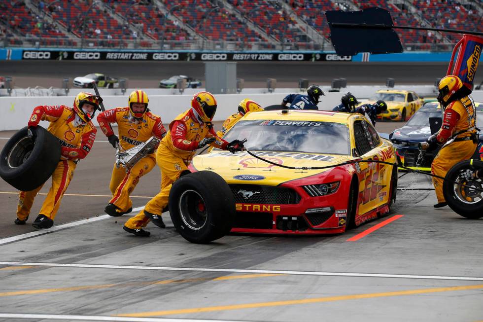 The pit crew for Joey Logano (22) scramble around the car on a pit stop during a NASCAR Cup Ser ...