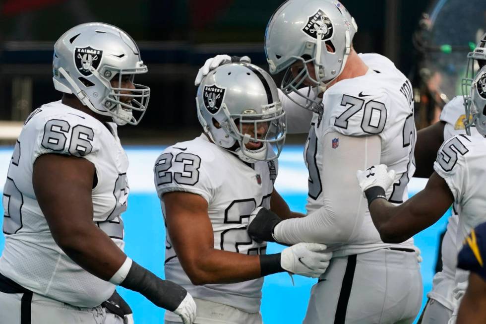 Las Vegas Raiders running back Devontae Booker (23) reacts with teammates offensive tackle Sam ...