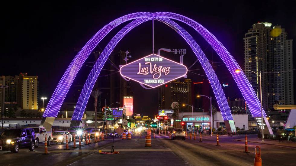 Cars stream up Las Vegas Boulevard as the downtown gateway arches are fully illuminated for the ...