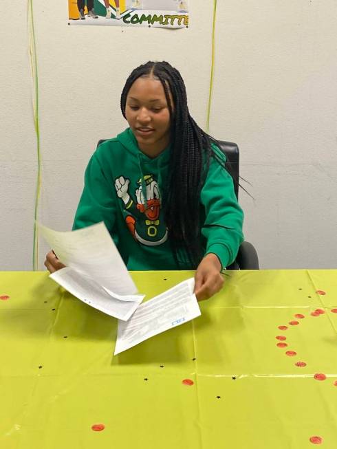 Centennial guard Taylor Bigby signs with Oregon on Wednesday night at the Centennial Hills YMCA ...