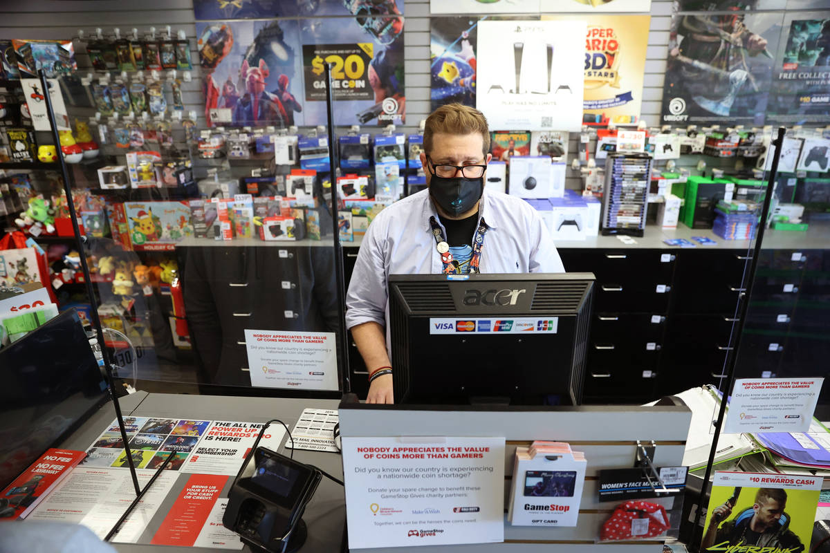 Assistant manager Eric Crosby processes the Play Station 5 console order for a customer at Game ...